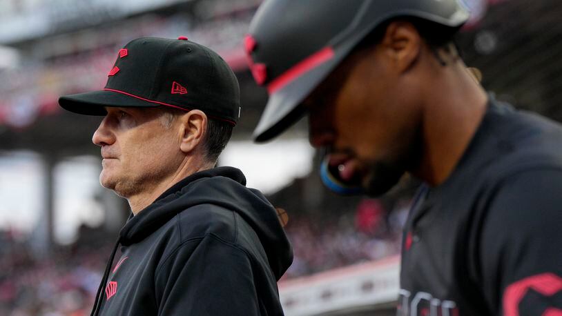 Cincinnati Reds manager David Bell, left, stands in the dugout with Will Benson during the second inning of the team's baseball game against the New York Mets on Friday, April 5, 2024, in Cincinnati. (AP Photo/Jeff Dean)