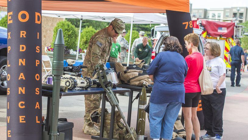 An explosive ordnance technician with the 788th Explosive Ordnance Disposal unit from Wright-Patterson Air Force Base explains his unit’s mission and equipment used which is on display outside Fifth Third Field in downtown Dayton prior to the Dayton Dragons salute to hometown heroes, Aug. 5, 2017. The third annual Wright-Patterson Air Force Base EOD Memorial 5K will be held May 5 on National EOD Day and honors members of the armed forces who have risked their lives disposing of explosives. (U.S. Air Force photo/ Wesley Farnsworth) (Contributed photo)