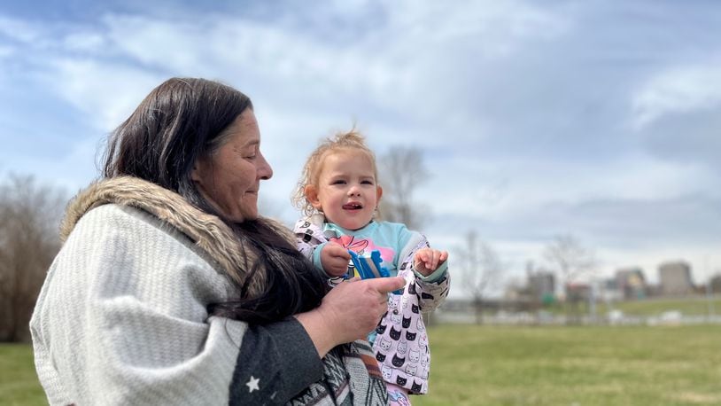 Kate South, a South Park resident, flies a kite on Thursday with her 2-year-old granddaughter Victoria Beeker in a large field near Emerson Academy. The downtown Dayton skyline can be seen in the distance. CORNELIUS F