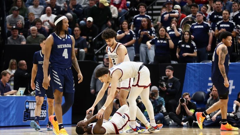 Dayton's Nate Santos and Koby Brea help up Kobe Elvis after he drew a foul against Nevada in the first round of the NCAA tournament on Thursday, March 21, 2024, at the Delta Center in Salt Lake City, Utah. David Jablonski/Staff