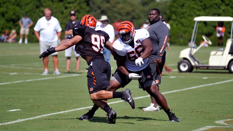 Cincinnati Bengals rookie defensive end Jordan Willis (99) goes against offensive lineman Trey Hopkins in a one-on-one blocking drill Sunday in the first training camp practice in shoulder pads. JAY MORRISON/STAFF
