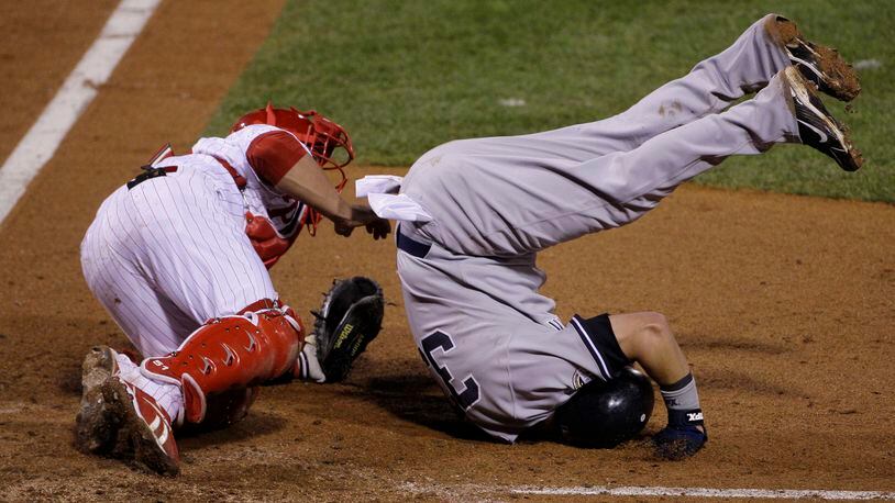 New York Yankees’ Nick Swisher flips upside down after colliding with Philadelphia Phillies’ Carlos Ruiz after scoring on a Andy Pettitte single during the fifth inning of Game 3 of the Major League Baseball World Series Saturday, Oct. 31, 2009, in Philadelphia. (AP Photo/Julie Jacobson)