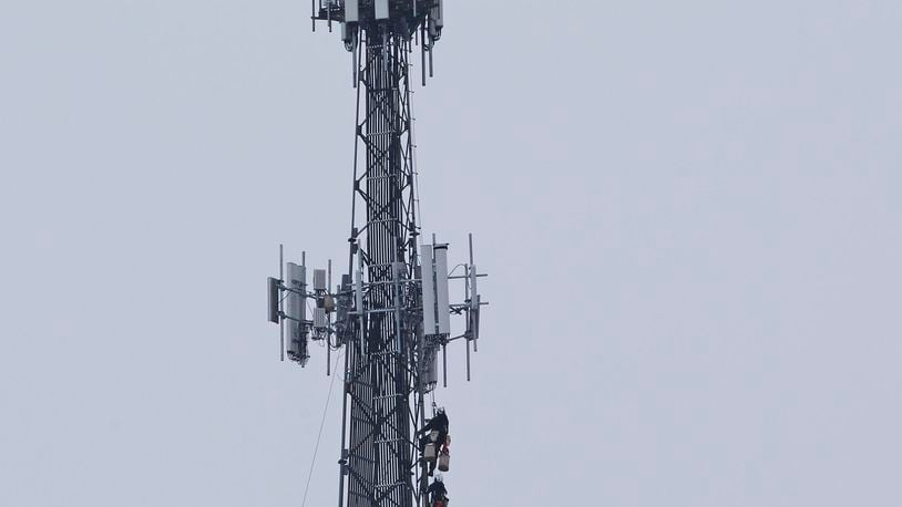Communication workers recently were hoisted to the top of a cell tower along U.S. 35 in Beavercreek. This tower has multiple carriers’ antennae and reaches nearly 300-feet tall. TY GREENLEES / STAFF