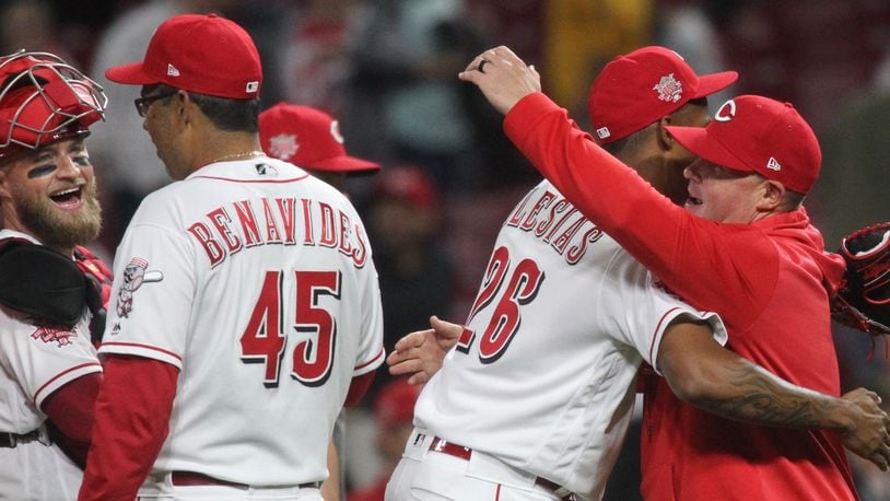 Reds reliever Raisel Iglesias hugs pitching coach Derek Johnson after a victory against the Braves on Tuesday, April 23, 2019, at Great American Ball Park in Cincinnati. David Jablonski/Staff