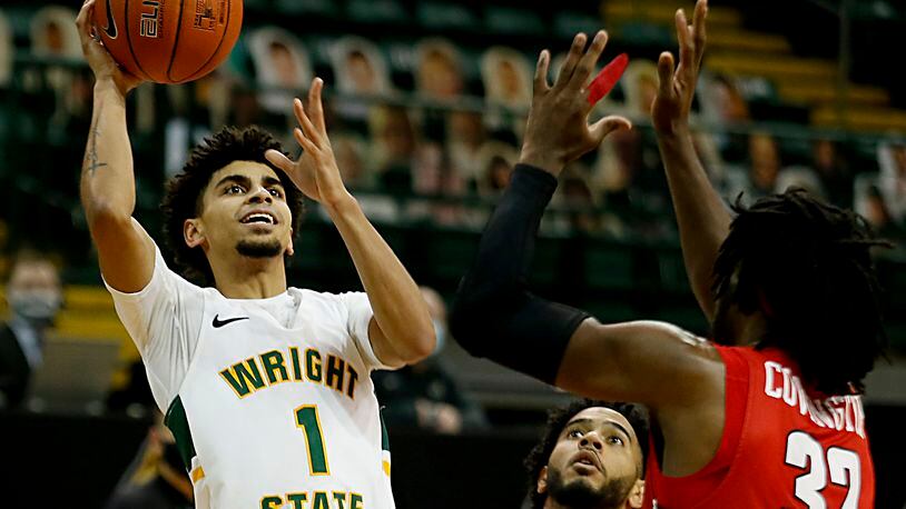 Wright State guard Trey Calvin shoots while covered by Youngstown State guards Shemar Rathan-Mayes (22) and Garrett Covington (32) during a Horizon League game at the Nutter Center in Fairborn Jan. 9, 2021. Wright State won 93-55. Contributed photo by E.L. Hubbard