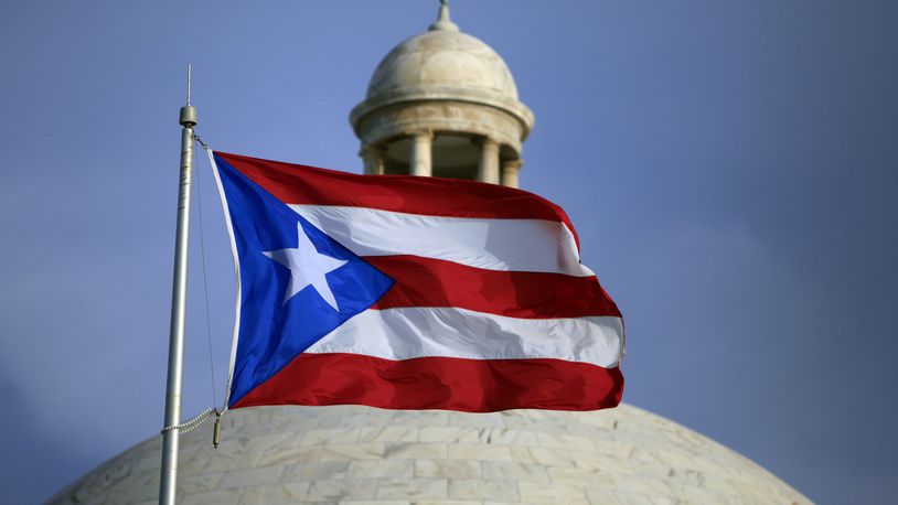 FILE - The Puerto Rican flag flies in front of Puerto Rico's Capitol as in San Juan, Puerto Rico, July 29, 2015. Puerto Rico’s Republican Party held a district assembly Sunday, April 21, 2024, and awarded former President Donald Trump all 23 of their national delegates. About 77% of the 1,340 members that make up the U.S. territory’s Republican Party participated. (AP Photo/Ricardo Arduengo, File)