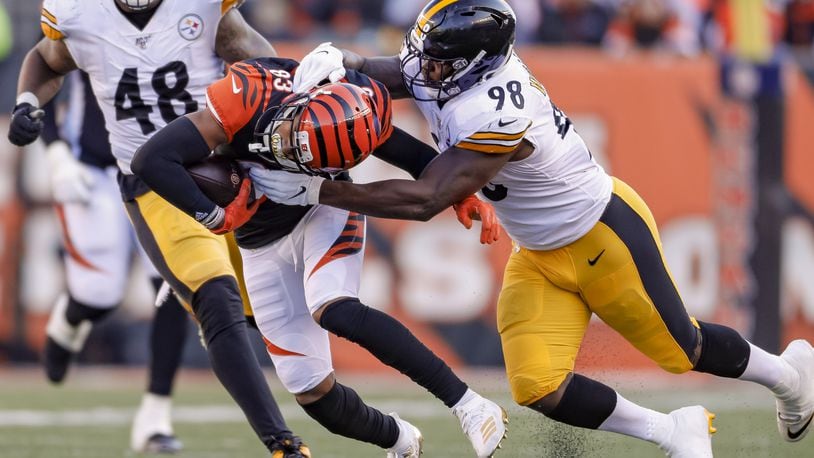 CINCINNATI, OH - NOVEMBER 24: Tyler Boyd #83 of the Cincinnati Bengals runs the ball and is grabble for a tackle by Vince Williams #98 of the Pittsburgh Steelers at Paul Brown Stadium on November 24, 2019 in Cincinnati, Ohio. (Photo by Michael Hickey/Getty Images)