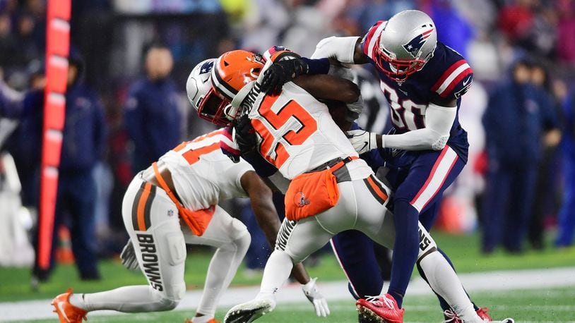 FOXBOROUGH, MASSACHUSETTS - OCTOBER 27: Running back Dontrell Hilliard #25 of the Cleveland Browns is tackled by outside linebacker Jamie Collins #58 and cornerback Jason McCourty #30 of the New England Patriots in the second quarter of the game at Gillette Stadium on October 27, 2019 in Foxborough, Massachusetts. (Photo by Billie Weiss/Getty Images)