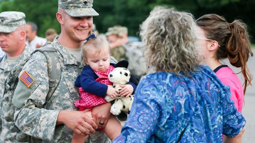 Josh Moore greets his daughter Adaline, 15 months, his wife Katherine, and other family members after returning from deployment, Thursday, Aug. 4, 2016. More than 100 members of the Middletown-based Ohio Army National Guard's 324th Military Police Co. returned to a Welcoming Ceremony at Franklin High School after an 11-month deployment guarding prisoners at Guantanamo Bay, Cuba. GREG LYNCH / STAFF