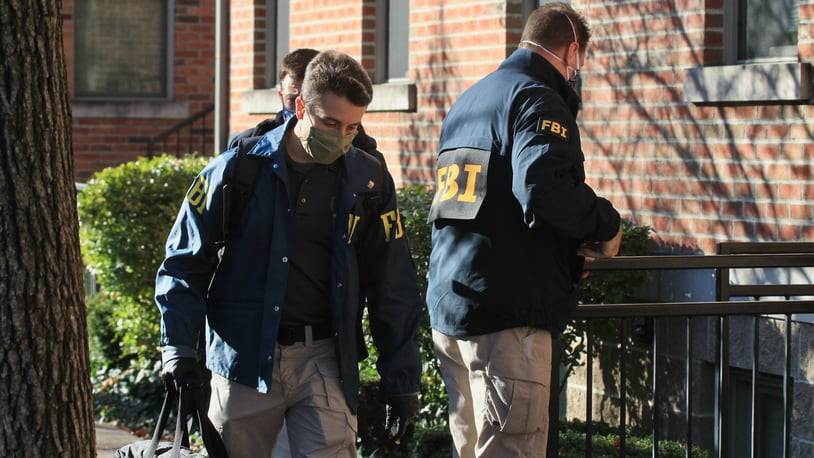 Federal agents bring out boxes after searching a Columbus condo owned by Sam Randazzo, chairman of the Public Utilities Commission of Ohio, on Monday, Nov. 16, 2020, in Columbus. David Jablonski/Staff