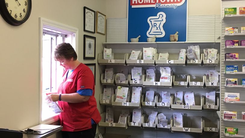 An employee helps a customer at the drive-up window of Sidney Hometown Pharmacy on Aug. 29, 2017.