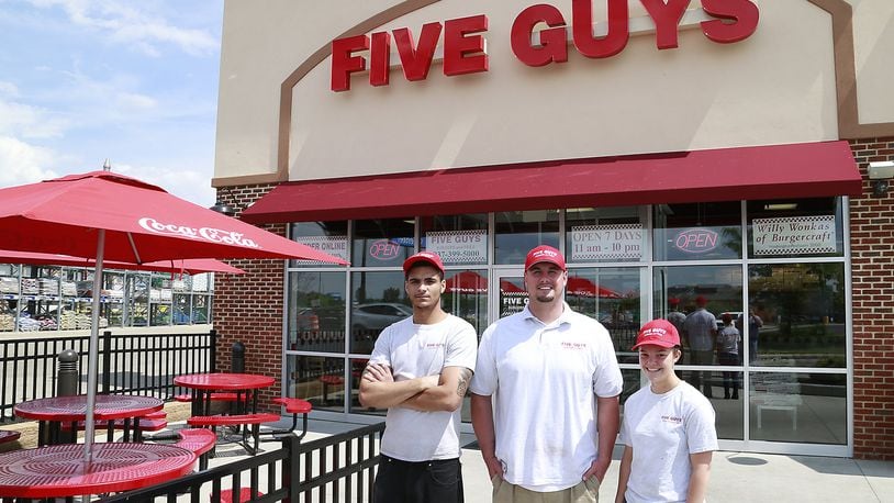 Five Guys with the management staff, Damon Roush, David Day and Autum Baer in front of the Bechtle Avenue location. BILL LACKEY/STAFF