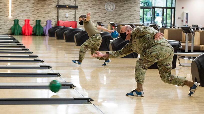 Col. Patrick Miller (right), 88th Air Base Wing and installation commander, rolls a ball down the lane during the Eagles vs. Chiefs Bowling Challenge at Wright-Patterson Air Force Base. U.S. AIR FORCE PHOTO/FARNSWORTH