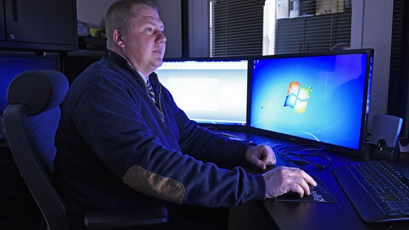 Miami University Police Department Detective Walt Schneider surrounded by monitors and specialized equipment in his Oxford office. Schneider, a digital forensic examiner, has been trained by the Secret Service. He helps agencies from Butler County and beyond who need help gathering evidence in cyber crimes.
