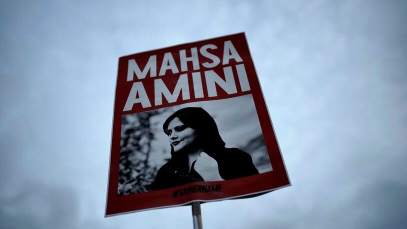 FILE - A woman holds a placard with a picture of Iranian woman Mahsa Amini during a protest against her death, in Berlin, Germany, on Sept. 28, 2022. A rapper in Iran who came to fame over his lyrics about the 2022 death of Mahsa Amini and criticizing the Islamic Republic has been reportedly sentenced to death, state media and rights activists said Thursday, April 25, 2024. (AP Photo/Markus Schreiber, File)