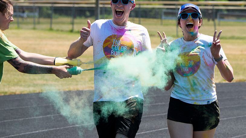 Staff Sgt. Caroline Berglin sprays a pair of runners as they circle the Jarvis track during the color run June 30 at Wright-Patterson Air Force Base. Following the color run, there were games, booths and food trucks for people to observe the end of Pride Month. U.S. AIR FORCE PHOTO/R.J. ORIEZ