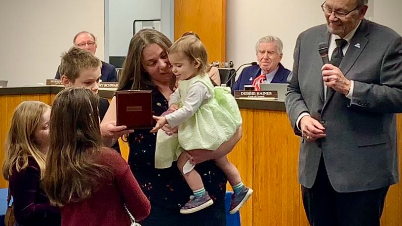 Anthony Diehl’s partner, Laura Steele, and their children accept the Carnegie Medal for Heroism, awarded to Diehl posthumously. Beavercreek Mayor Don Adams (right) looks on. LONDON BISHOP/STAFF