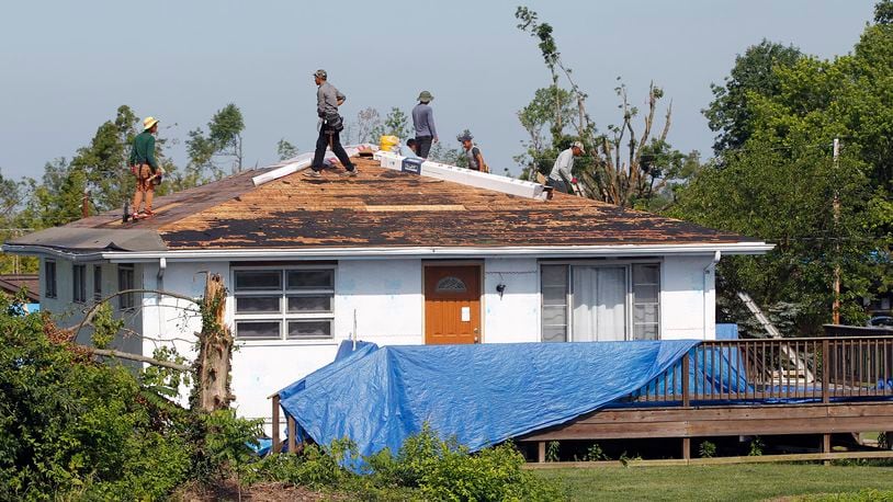 Workers begin the process of reroofing this house on Graham Drive in Beavercreek that was damaged by the Memorail Day tornado. The City of Beavercreek announced on Thursday that it will end pickup of tree debris from residences on July 28. TY GREENLEES / STAFF