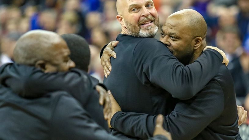 Trotwood-Madison High School boys basketball coach Rocky Rockhold hugs Rams assistant coach Tony Clemens after the Rams beat Columbus South 77-73 in the Division II state championship game at the Ohio State University Jerome Schottenstein Center in Columbus. CONTRIBUTED PHOTO BY MICHAEL COOPER