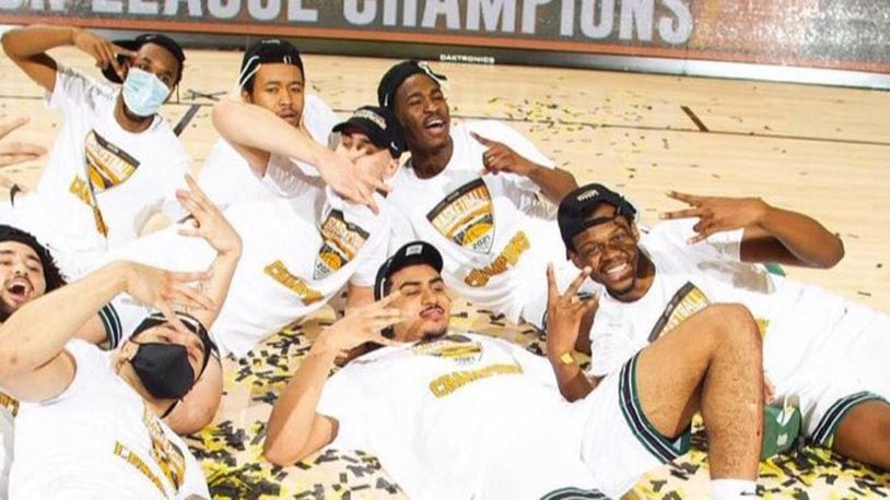Torrey Patton (lying in front, second from right)  and teammates celebrate on the confetti-strewn court at Indiana Farmers Coliseum after their Cleveland State Vikings beat Oakland Tuesday night to win the Horizon League Tournament and advance to the NCAA tournament. Patton scored a game high 23 points and had 10 rebounds. He was named the MVP of the Horizon League Tournament. (Contributed photo courtesy of Horizon League)