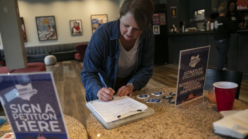 
                        An Ohio voter, Lysha Ingle, signs a petition to place an amendment protecting abortion rights in the state constitution on the ballot, in Cincinnati, April, 21, 2023. After abortion rights supporters swept six ballot measures last year, Republican legislatures seek to make it harder to get on the ballot, and harder to win if there is a vote. (Maddie McGarvey/The New York Times)
                      