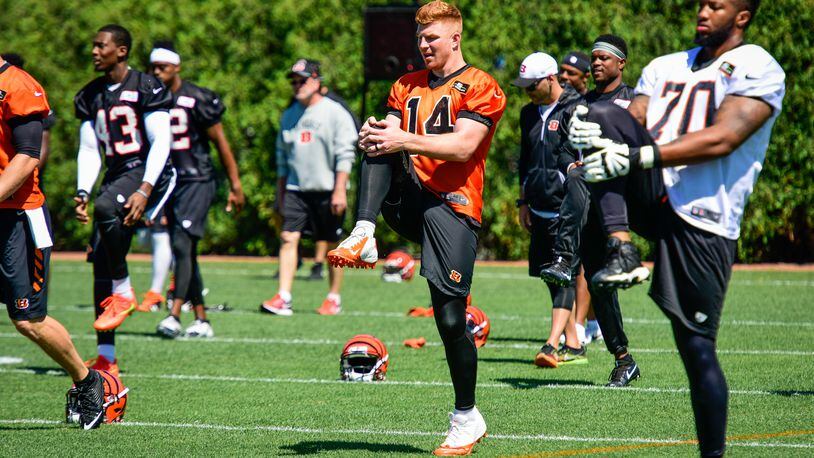 Cincinnati Bengals quarterback Andy Dalton (14) and offensive tackle Cedric Ogbuehi (70) stretch during practice Tuesday, June 6 on their practice fields next to Paul Brown Stadium in Cincinnati. NICK GRAHAM/STAFF