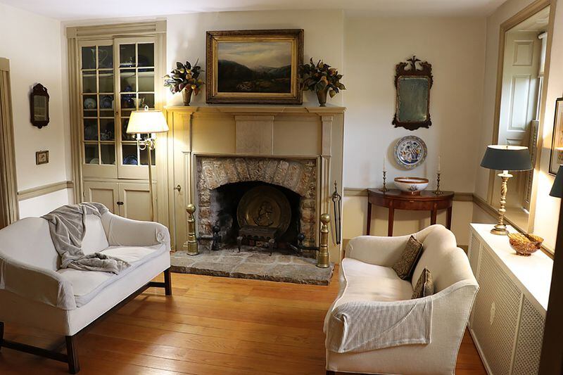 The original stone fireplace is the centerpiece to the living room and has an arched opening, stone hearth and hand-carved wood mantel and surround. CONTRIBUTED PHOTO BY KATHY TYLER