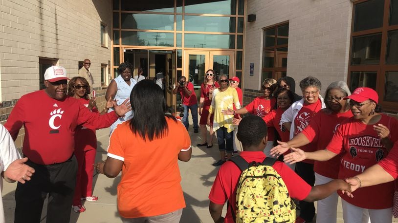 Dayton Public Schools employees and school board members join community leaders and graduates of the former Roosevelt High School in welcoming students to the first day of classes Monday at Roosevelt Elementary on West Third Street. The school, which was called Dayton Boys Prep in recent years, was renamed Roosevelt because Boys Prep was combined with the World of Wonder school that closed in May 2019. CHUCK HAMLIN / STAFF