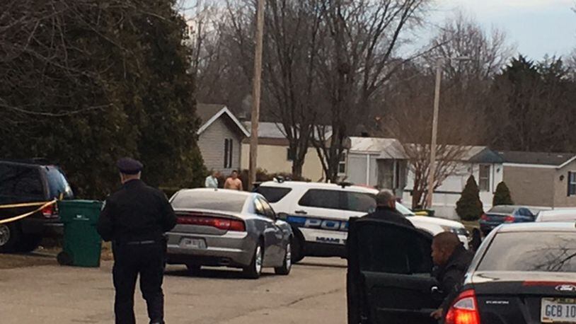 Miami Township police and bystanders in the area near the deadly officer-involved shooting in Oakwood Village this morning. NICK BLIZZARD/STAFF PHOTO