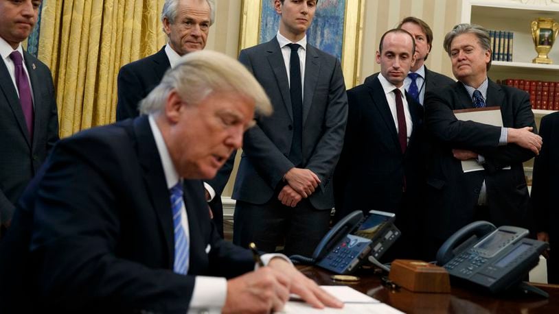 From left, White House Chief of Staff Reince Priebus, National Trade Council adviser Peter Navarro, Senior Adviser Jared Kushner, policy adviser Stephen Miller, and chief strategist Steve Bannon watch as President Donald Trump signs an executive order in the Oval Office of the White House, Monday, Jan. 23, 2017, in Washington. (AP Photo/Evan Vucci)