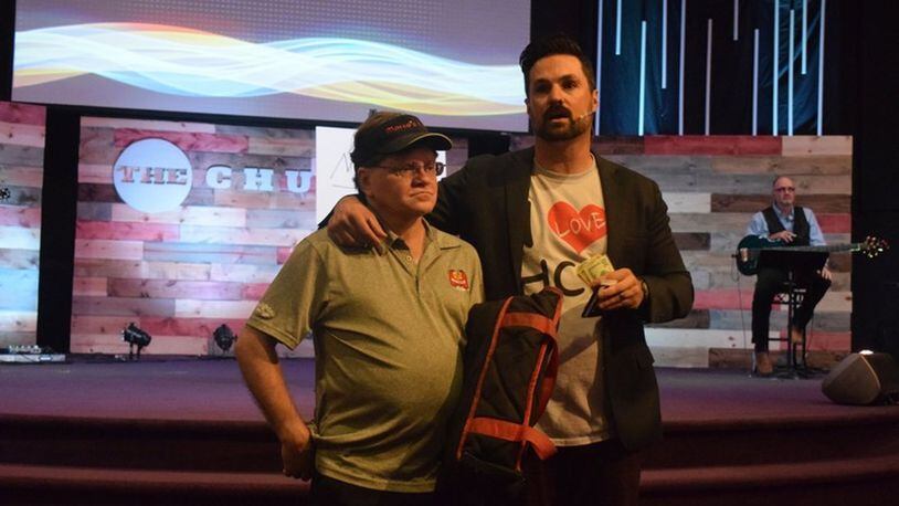 Curtus Moak (right), lead pastor at Hamilton Christian Center, surprised pizza delivery driver Kenny Sharp (left) with a tip in the amount of $3,000. Now, Moak is working on taking a group of athletes on a mission trip to Nicaragua.