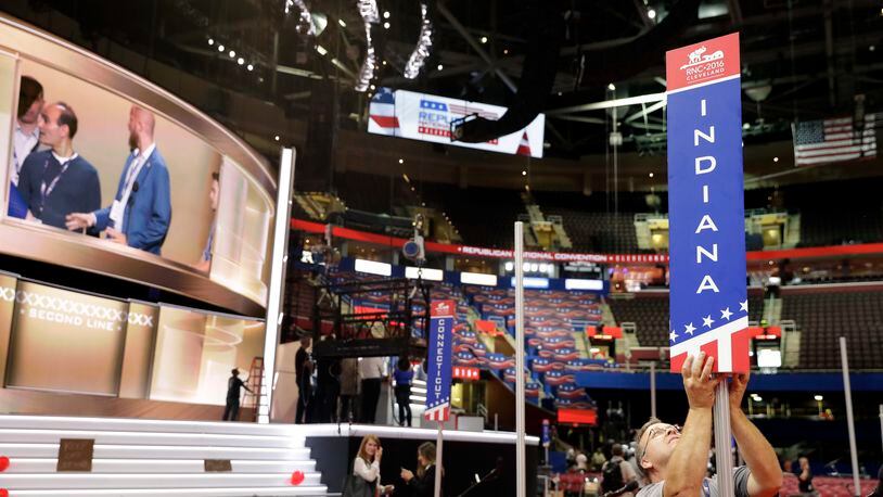 Tom Sondels makes an adjustment to the Indiana state delegation placard as preparations continue for the Republican National Convention, Friday, July 15, 2016, at the Quicken Loans Arena in Cleveland. (AP Photo/Alex Brandon)