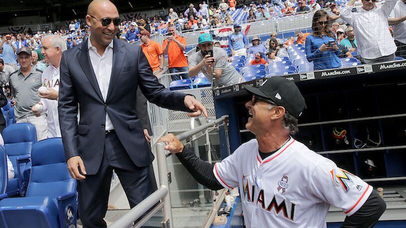 Miami Marlins CEO Derek Jeter, left, speaks with Manager Don Mattingly during the Marlins' home opener against the Chicago Cubs on March 29, 2018 in Miami. (Pedro Portal/Miami Herald/TNS)