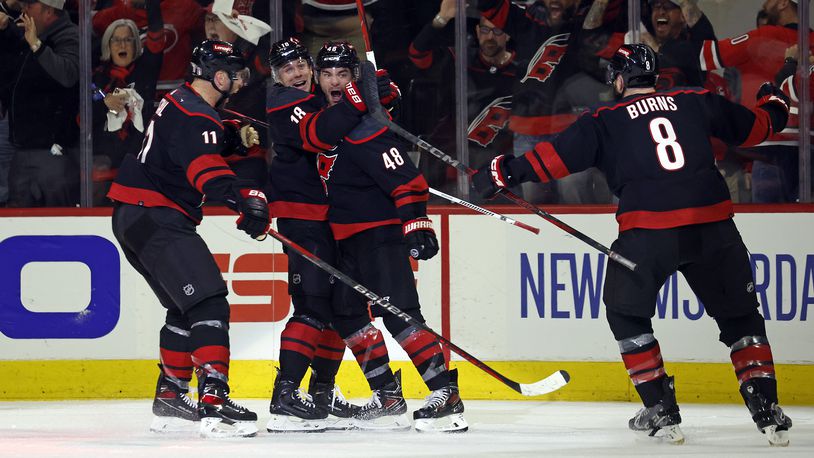 Carolina Hurricanes' Jordan Martinook (48) celebrates after his winning goal with teammates Jack Drury (18), Jordan Staal (11) and Brent Burns (8) during the third period in Game 2 of an NHL hockey Stanley Cup first-round playoff series against the New York Islanders in Raleigh, N.C., Monday, April 22, 2024. (AP Photo/Karl B DeBlaker)