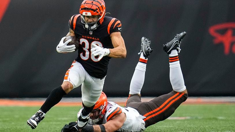 Cincinnati Bengals running back Chase Brown (30) escapes from Cleveland Browns linebacker Jordan Kunaszyk (51) during the first half of an NFL football game in Cincinnati, Sunday, Jan. 7, 2024. (AP Photo/Sue Ogrocki)