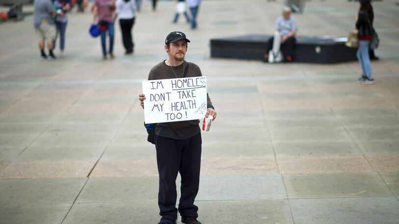 FILE PHOTO: A man carries a sign reading "I'm homeless, don't take my health too!" before a health care rally at Thomas Paine Plaza on February 25, 2017 in Philadelphia, Pennsylvania.  (Photo by Mark Makela/Getty Images)