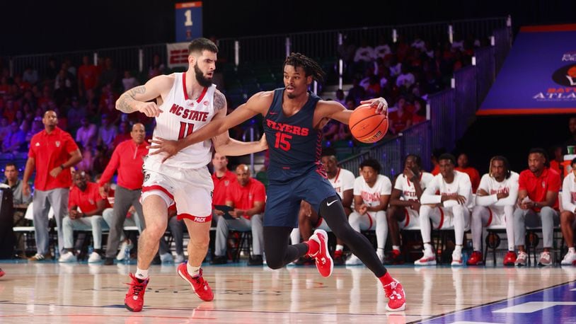 Dayton's DaRon Holmes II dribbles against N.C. State's Dusan Mahorcic in the first half on Thursday, Nov. 24, in the consolation round of the Battle 4 Atlantis at Imperial Arena at the Atlantis Paradise Island resort. David Jablonski/Staff