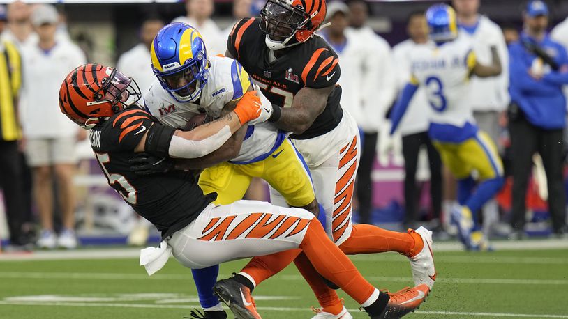Los Angeles Rams running back Cam Akers, middle, is tackled by Cincinnati Bengals inside linebacker Logan Wilson, left, and outside linebacker Germaine Pratt during the first half of the NFL Super Bowl 56 football game Sunday, Feb. 13, 2022, in Inglewood, Calif. (AP Photo/Chris O'Meara)
