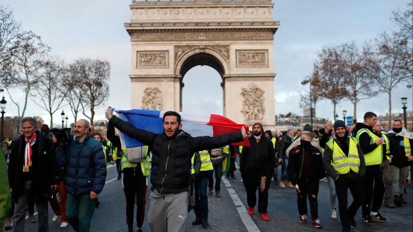 Demonstrators wearing yellow vests march down the Champs Elysees in Paris on Saturday.