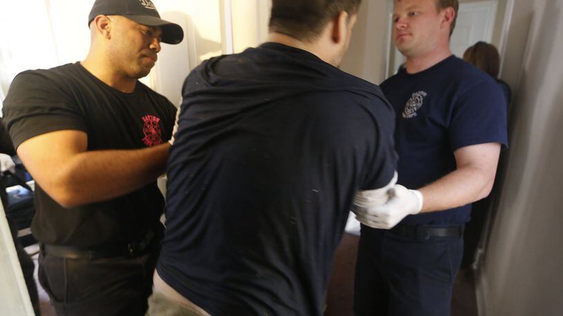 Dayton medics remove an overdose patient from a house in October. Dayton Police Department Officer Joe Sheen was first to arrive and administer naloxone to a man suffering an opioid overdose. It took Sheen and Dayton Fire Department medics 12 doses of naloxone to revive the man who later said he took a pink pill. Medics and police suspect the pill contained carfentanil. CHRIS STEWART / STAFF