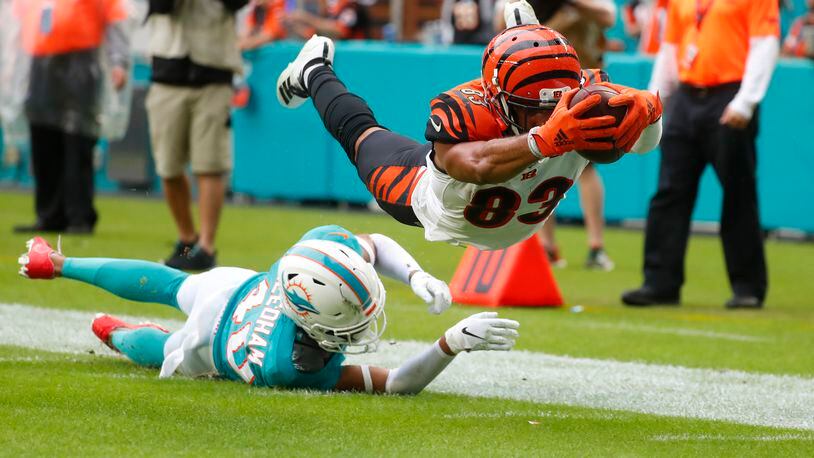 Cincinnati Bengals wide receiver Tyler Boyd (83) stretched for a touchdown as Miami Dolphins defensive back Nik Needham (40) is unable to defend, during the second half at an NFL football game, Sunday, Dec. 22, 2019, in Miami Gardens, Fla. (AP Photo/Wilfredo Lee)
