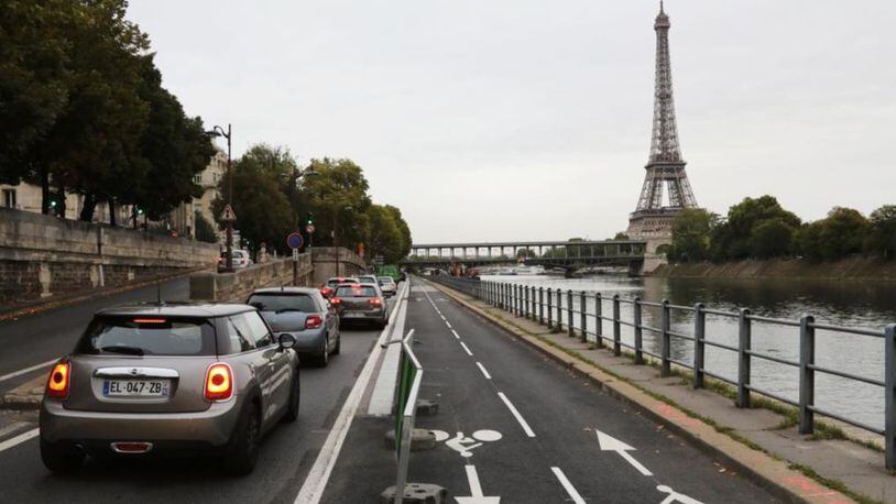 A picture taken on September 4, 2017 shows the newly created bicycle track next to cars stuck in a traffic jam along the Seine River near the Bir Hakeim Bridge in Paris. 
In 2015, the city launched the 'Plan Vélo', a project worth 150 million euros, with the aim of doubling the number of kilometres of cycling tracks (from 700 to 1,400 km) among others.  (LUDOVIC MARIN/AFP/Getty Images)