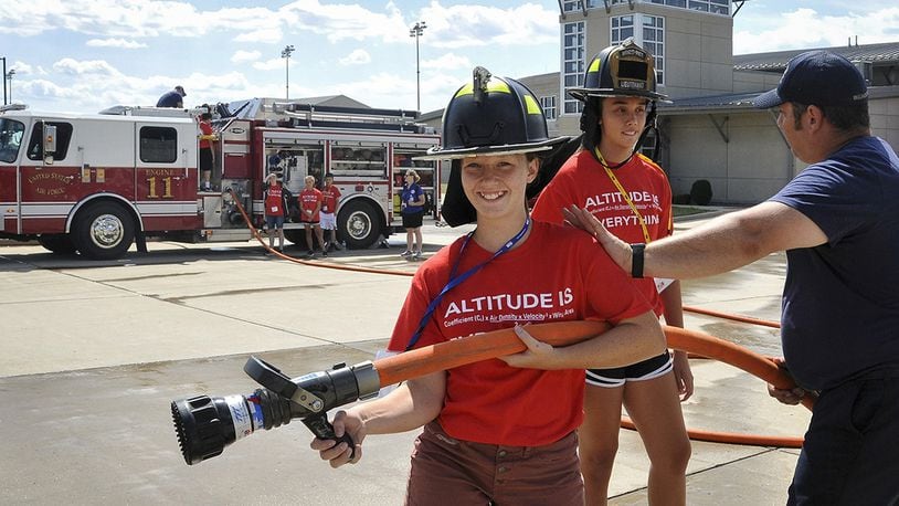 Dakota Wagner (left) and Savannah Smith (center) learn what it’s like to be a firefighter during their second day of Air Camp at Wright-Patterson Air Force in July 2018. (U.S. Air Force photo/Isabel Velez)