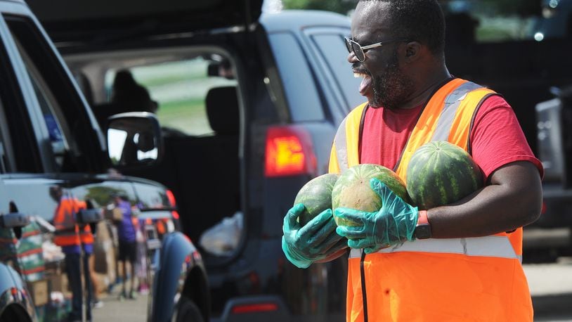Veto Mason helps with The Foodbank Inc. drive-thru food distribution at the old Salem Mall in Trotwood Thursday Spet. 15, 2022. MARSHALL GORBY\STAFF