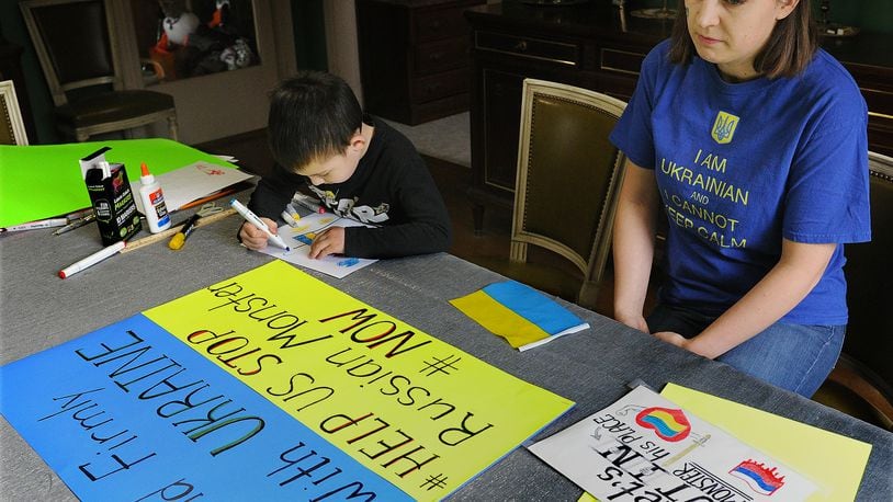 Anastasia Nagle with her son Christoper, age 6, prepare posters for a upcoming rally to show support for the Ukraine. MARSHALL GORBY\STAFF