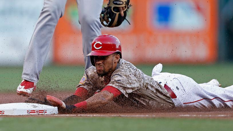 Cincinnati Reds' Billy Hamilton is safe at third with a stolen base against the St. Louis Cardinals during the first inning of a baseball game, Friday, Sept. 2, 2016, in Cincinnati. (AP Photo/Gary Landers)
