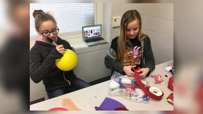 Simon Kenton Elementary sixth grade students Kylee Wilson and Mandy Henry create items based on the popular video game, “Five Nights at Freddy’s,” to sell at a Market Day event on Tuesday. Photo by Brett Turner
