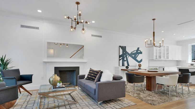 Two similar yet different brass industrial chandeliers complement a combined dining/living room area. (H5 Property)