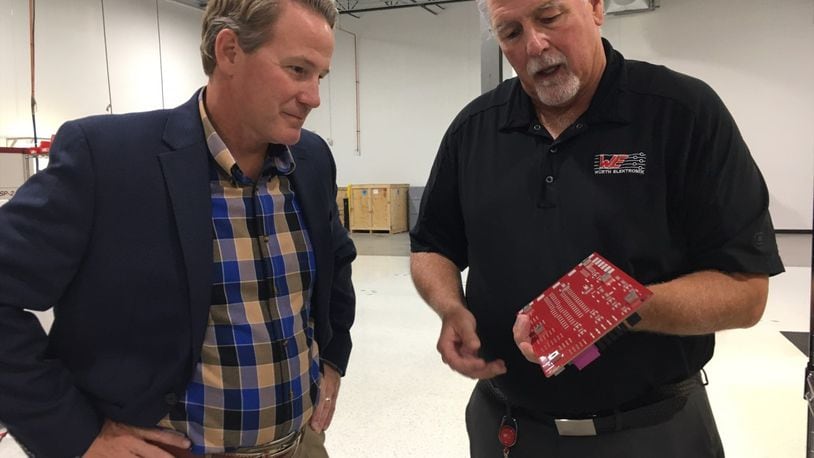 Ken Baker, vice president of opeations at Wurth Electronics-ICS Inc. in Miamisburg, right, shows Ohio Lt. Gov. Jon Husted one of the company’s printed circuit boards Friday, which was Manufacturing Day 2021. THOMAS GNAU/STAFF