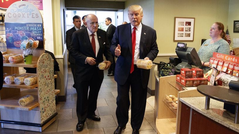 FILE - In this Oct. 10, 2016, file photo, former New York mayor Rudy Giuliani, left, stands with then-Republican presidential candidate Donald Trump as he buys cookies during a visit to Eat’n Park restaurant in Moon Township, Pa. Will President-elect Trump remake school lunches into his fast-food favorites of burgers and fried chicken? Children grumbling about healthier school meal rules championed by first lady Michelle Obama may have reason to cheer Trump’s election. The billionaire businessman is a proud patron of quick food restaurants and is promising to curb federal regulations. (AP Photo/Evan Vucci, File)